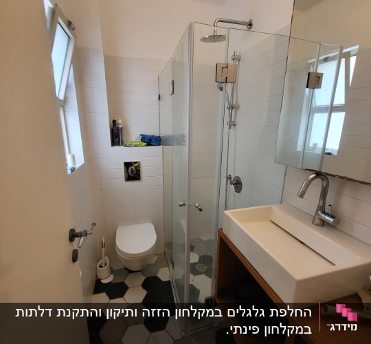 מקלחון זכוכית עם ראש מקלחת עגול ומדף מוצרים